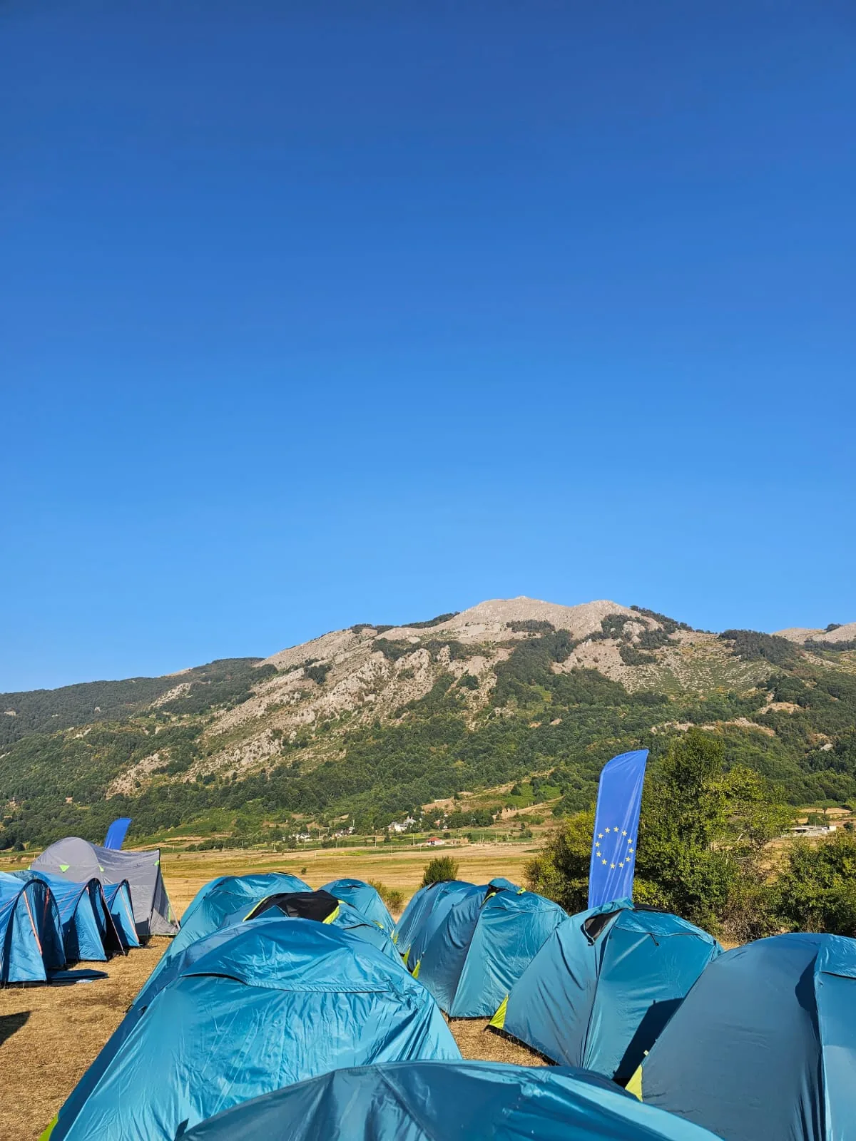 Blue tents with an EU flag in the valley