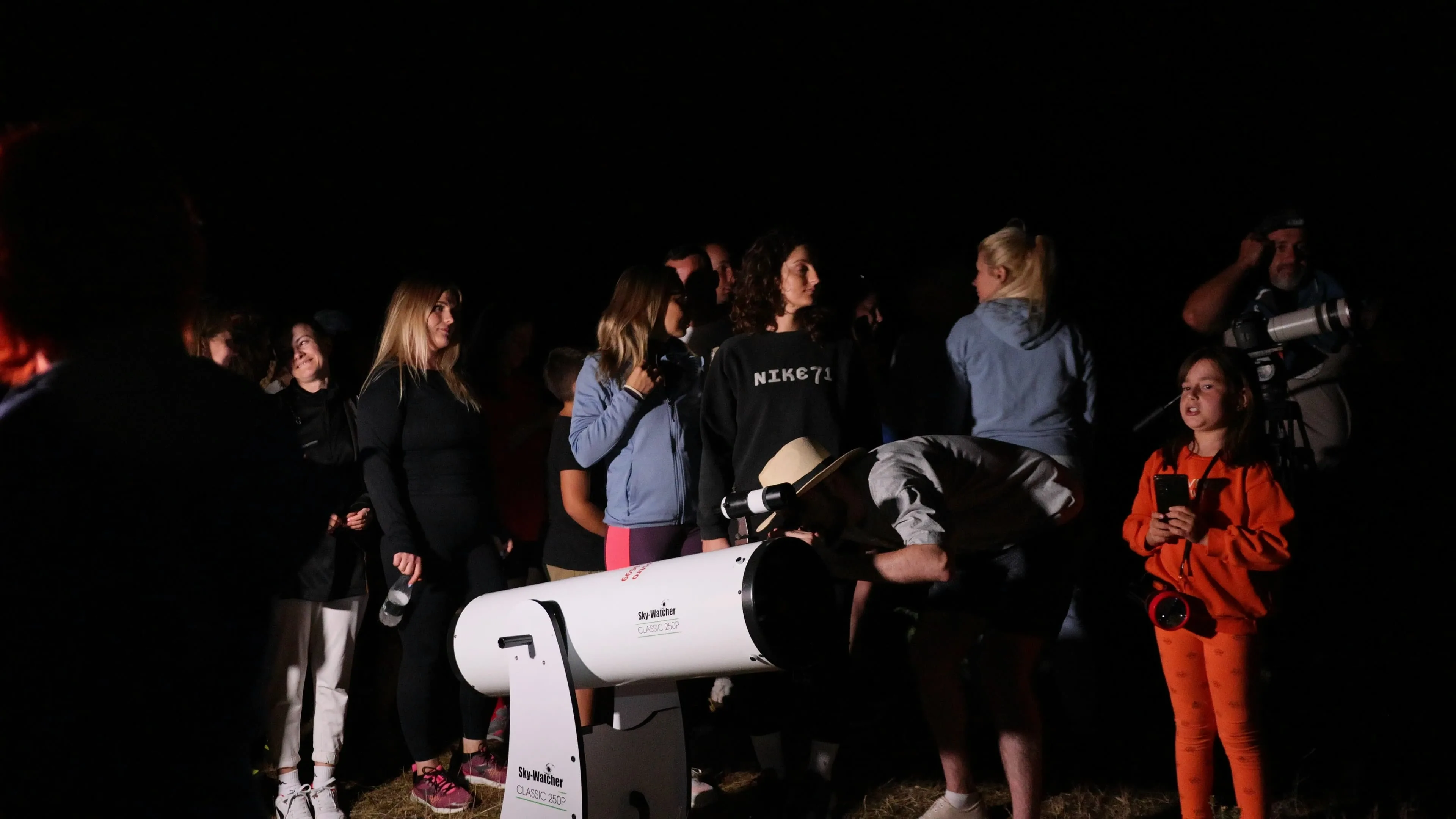 Children looking through a large telescope