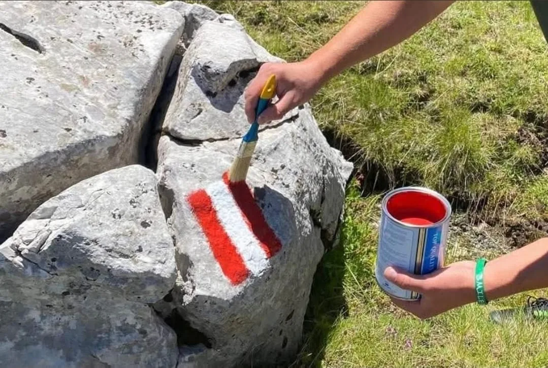 Painting a trail marker on a rock